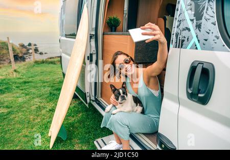 Frau, die mit ihrem Hund vor der Tür des Wohnwagens fotografiert Stockfoto