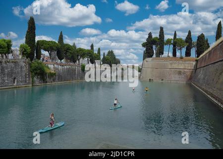 Paddelboarder auf dem Kanal in Peschiera del Garda, Italien am sonnigen Tag des 05. Mai 2022. Stockfoto