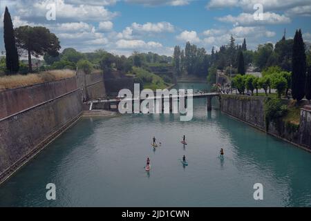 Paddelboarder auf dem Kanal in Peschiera del Garda, Italien am sonnigen Tag des 05. Mai 2022. Stockfoto