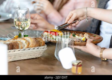 Der Kellner bedient Restaurantgäste. Gäste im Restaurant Stockfoto