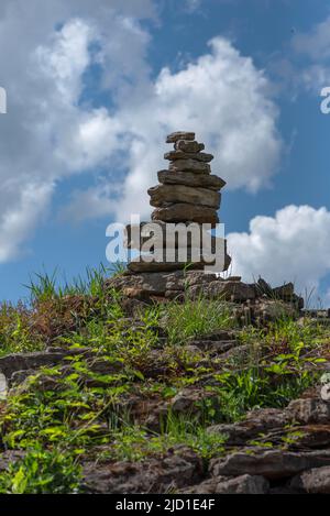 Übereinander gestapelte Steine, cairns mit bewölktem Himmel, Schlosspark Dennenlohe, Mittelfranken, Bayern, Deutschland Stockfoto