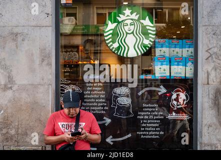 Madrid, Spanien. 28.. Mai 2022. Ein Mann nutzt sein Smartphone vor der amerikanischen multinationalen Kette Starbucks Coffee Store in Spanien. (Bild: © Xavi Lopez/SOPA Images via ZUMA Press Wire) Stockfoto