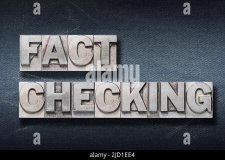 Fact Checking Phrase aus Metallic-Buchdruck auf dunklem Jeans-Hintergrund Stockfoto