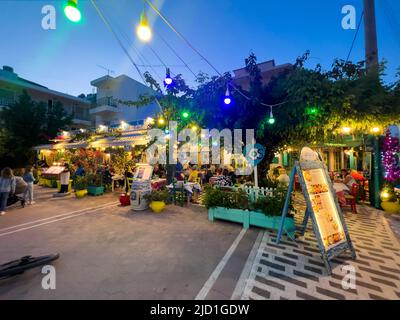 Kos-Griechenland, 05.31.2022: Geschäfte im Stadtzentrum von Kos Island. Traditionelle griechische Restaurants mit bunten Lichtern in der Nacht. Stockfoto