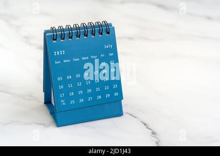 Juli 2022 Tischkalender in blauer Farbe auf dem Schreibtisch mit Platz für Kopien Stockfoto