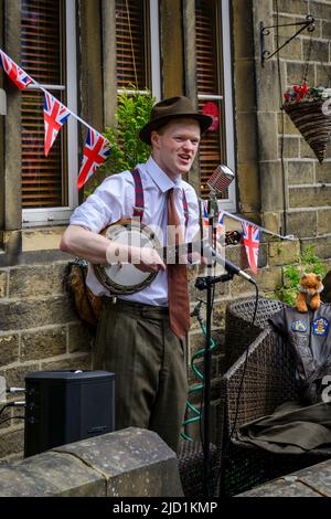 Haworth 1940 Veranstaltung zum Leben in der Geschichte (Solist, Live-Musik-Player, Retro-Kleidung, Klamotten, Mikrofone) - Main Street, West Yorkshire England UK Stockfoto