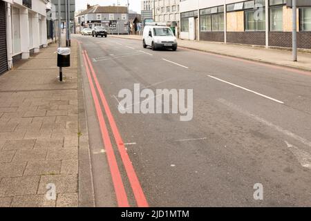 Doppelte rote Linie in der Nähe von Bordstein auf Asphaltstraße. Diese zeigen an, dass das Stoppen jederzeit verboten ist, Stockfoto