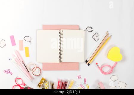Girly rosa Schreibtisch und Schreibwaren mit leerem Notizbuch. Rahmen aus buntem Papeterie. Zurück zum Schulkonzept. Flatlay, Mock Up. Stockfoto