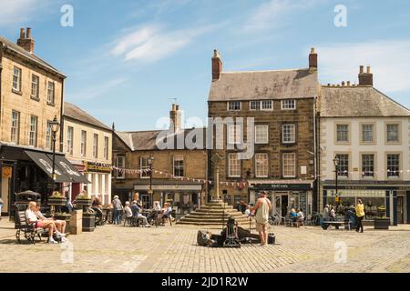 Ein Busfahrer tritt auf dem Alnwick Market Square, Northumberland, England, Großbritannien, auf Stockfoto