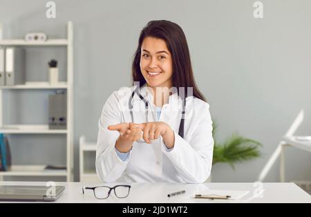 Kamera-Ansicht junge Frau Hausarzt trägt medizinische Kleid gibt Online-Konsultation zum Patienten Stockfoto