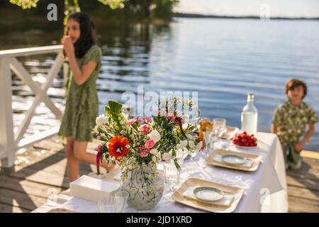 Kinder am Tisch am See Stockfoto