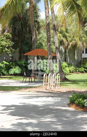 Ein ruhiger Ort zum Ausruhen mit einem Tisch, Stühlen und einem Sonnenschirm für Schatten. Stockfoto