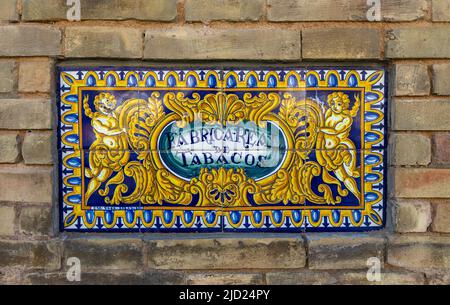 Keramikfliesen Zeichen der Royal Tobacco Factory (Real Fabrica de Tabacos), Backsteinmauer in Sevilla Spanien Jetzt Teil der Universität von Sevilla Stockfoto