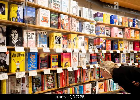 Ein Bucheinkäufer durchsucht die veröffentlichten Titel, die die Bücherregale in der Piccadilly-Filiale der Waterstones-Buchhandlung füllen, und insbesondere das Buch „A Luccily Woman: A Country Doctor's Story“ von Polly Morland am 7.. Januar 2022 in London, England. Stockfoto