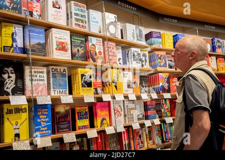 Ein Bucheinkäufer durchsucht die veröffentlichten Titel, die die Bücherregale in der Piccadilly-Filiale der Waterstones-Buchhandlung füllen, und insbesondere das Buch „A Luccily Woman: A Country Doctor's Story“ von Polly Morland am 7.. Januar 2022 in London, England. Stockfoto