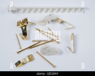 Bilderrahmen Wandaufhängung Zubehör-Kit aus weißem Nylon und Gold Messing Haken und brad Nägel Stockfoto