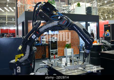 Der moderne Schweißroboter Yaskawa arbeitet am Stand in der Ausstellungshalle. Branchenmesse. 17. November 2021. Kiew, Ukraine Stockfoto