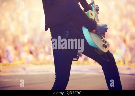 Tolle Power-Akkorde. Ausgeschnittene Aufnahme eines Gitarristen, der auf der Bühne auftrat. Stockfoto