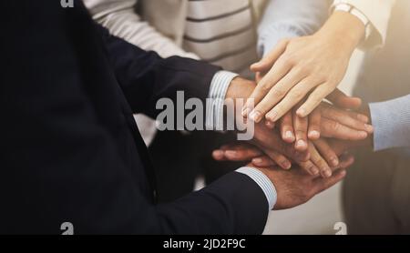 Wo Einheit ist, da ist Sieg. Ausgeschnittene Aufnahme einer Gruppe von Geschäftsleuten, die ihre Hände in Einheit zusammengelegt haben. Stockfoto