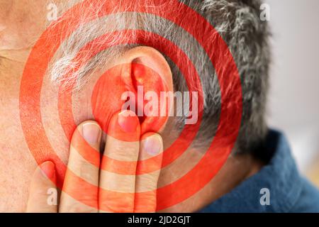 Nahaufnahme der Mann für Ohr mit Hand auf grauem Hintergrund Stockfoto