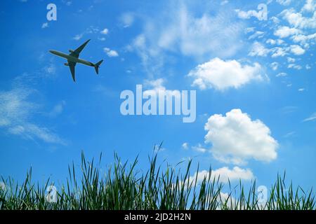 Silhouette eines Flugzeugs, das in einem strahlend blauen, sonnigen Himmel fliegt Stockfoto