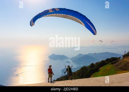 Fethiye, Mugla, Türkei - 28 2020. August: Mann mit Fallschirm bereitet den Start vom Berg Babadag vor. Paragliding-Konzept. Stockfoto