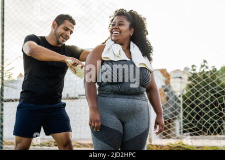 Personal Trainer arbeitet mit kurvigen Frau - Sport People Lifestyle-Konzept Stockfoto