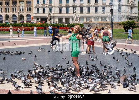 Eine Frau, die in Barcelona, Spanien, mit Tauben bedeckt ist. Stockfoto