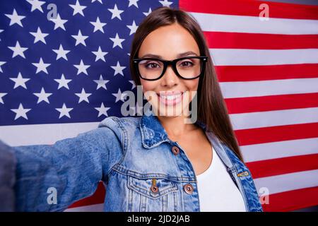 Foto von ziemlich positive Mädchen machen Selfie toothy Lächeln isoliert auf amerikanischer Nationalflagge Stockfoto