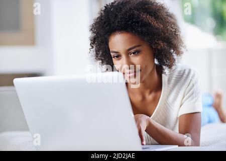 Aktualisieren der Inhalte ihrer Websites. Aufnahme einer jungen Frau, die ihren Laptop zu Hause benutzt. Stockfoto