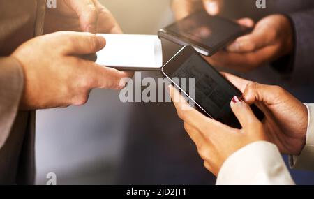 Geschäftserfolg ist alles über das Herstellen von Verbindungen. Aufnahme von Mitarbeitern, die ihre digitalen Geräte synchron nutzen. Stockfoto