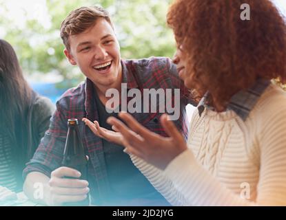 Einander kennenlernen. Eine kurze Aufnahme einer Gruppe von Freunden, die im Freien trinken. Stockfoto