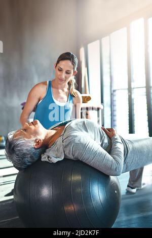 Verpflichtet, in jedem Alter aktiv und stark zu bleiben. Aufnahme einer älteren Frau, die mit ihrem Physiotherapeuten arbeitet. Stockfoto