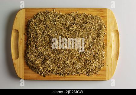 Trockene Mate-Blätter auf einem Holzbrett, traditionelles Getränk aus Argentinien. Hintergrund und Textur von trockenem Tee. Stockfoto