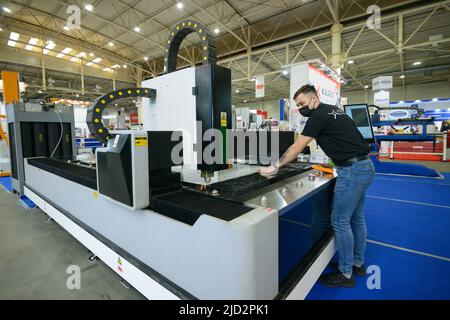 Lasermaschine Schneiden von Metallblech, Arbeiter läuft Bedienfeld. 17. November 2021. Kiew, Ukraine Stockfoto