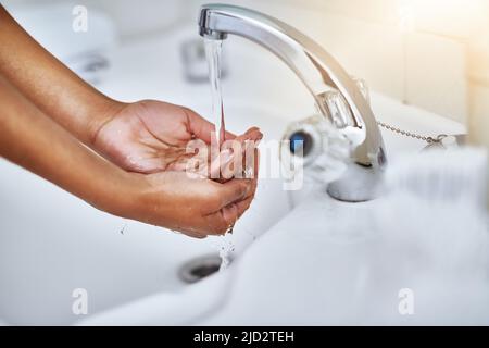 Keime und Bakterien im Abfluss. Ein kurzer Schuss einer Frau, die sich die Hände an einem Waschbecken im Badezimmer wusch. Stockfoto