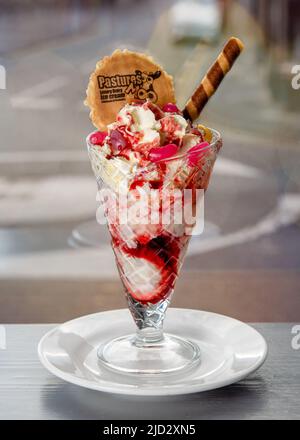 Eiscreme mit Waffeln und Waffeleisen auf einem Tisch in einem Café Stockfoto