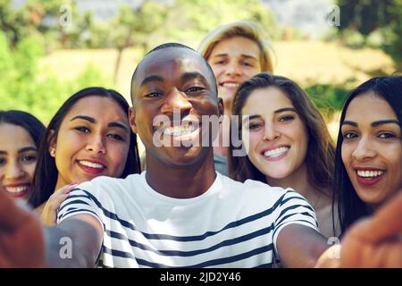 Nur uns. Aufnahme einer Gruppe junger Freunde, die im Freien ein Selfie machen. Stockfoto