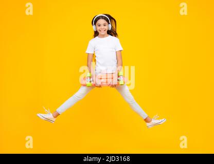 Teenager Lifestyle, lässige Jugendkultur. Teen Mädchen mit Skateboard über isoliert Studio Hintergrund. Springt und lauft. Cool modernen Teenager in stilvoll Stockfoto