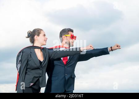 Geschäftsbeziehung in Superheldenanzug auf Himmel Hintergrund Stockfoto