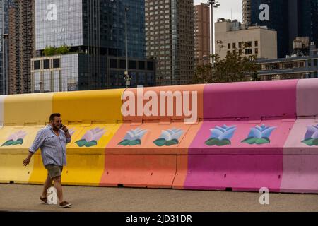 Mann, der vor einer Sicherheitsbarriere in Hudson Yards, Manhattan, NYC, mit dem Handy telefoniert Stockfoto