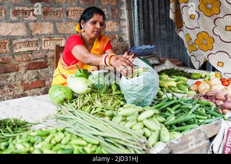 Weibliche Gemüsehändler in einem armen Slum in Kalkutta, Indien Stockfoto