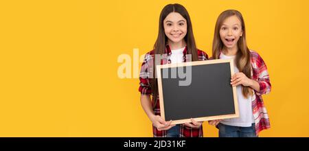 Schule Mädchen Freunde. Glückliche Kinder in lässig kariert halten Schule Tafel für Kopie Raum. Porträt einer Schülerin, Studio-Banner-Header Stockfoto