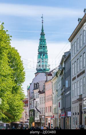 Der Turm und der Turm der alten Kirche Saint Nicolas (heute Zentrum für zeitgenössische Kunst Nikolaj) überragen die Geschäfte in Amagertorv. Kopenhagen, Dänemark Stockfoto