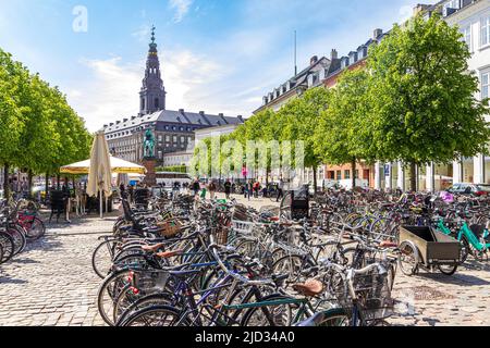 Viele Fahrräder auf dem Højbro Plads (Hochbrückenplatz), einem öffentlichen Platz in Kopenhagen, Dänemark - mit Blick auf den Turm von Christiansborg Slotskirke Stockfoto