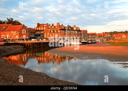 Blick über den Kanal zum Hafen, Kai und Hotel an der Nordnorfolk-Küste im Dorf Blakeney, Norfolk, England, Großbritannien. Stockfoto