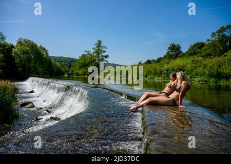 Die Menschen genießen das Wasser in Warleigh Weir am Fluss Avon in Somerset, während die Temperaturen über das Vereinigte Königreich steigen. Stockfoto