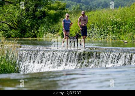Die Menschen genießen das Wasser in Warleigh Weir am Fluss Avon in Somerset, während die Temperaturen über das Vereinigte Königreich steigen. Stockfoto