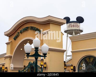 Paris, France - 04/05/2022: Wasserturm und Eingangsbogen zu den Walt Disney Studios in Disneyland Paris. Wolkiges Wetter. Menschen, die zum Tor gehen. Stockfoto