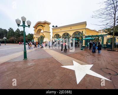 Paris, France - 04/05/2022: Wasserturm und Eingangsbogen zu den Walt Disney Studios in Disneyland Paris. Wolkiges Wetter. Menschen, die zum Tor gehen. Stockfoto